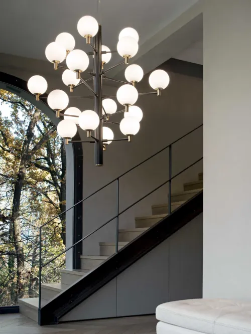 Lampada a sospensione Copernico in metallo verniciato nero opaco con dettagli in ottone e diffusori in vetro incamiciato bianco soffiato e acidato di Ideal Lux